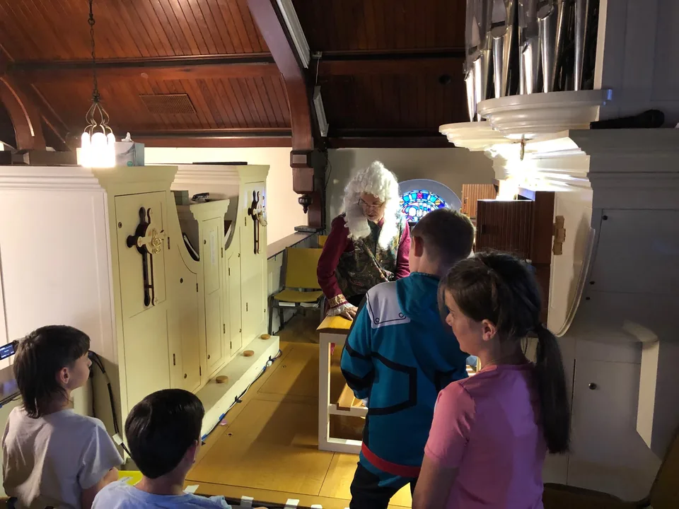 Children gathered at the organ console while the organist shows them how it works
