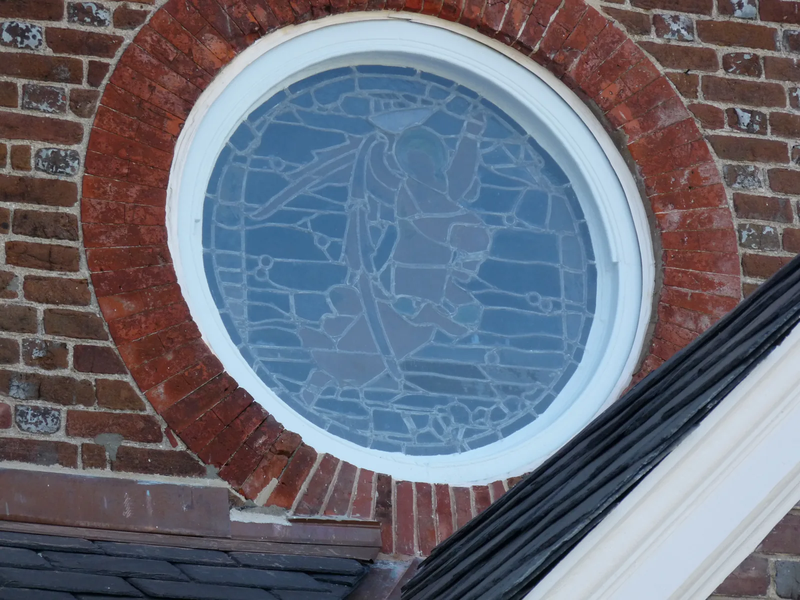 One of the church's round windows set in the brick wall