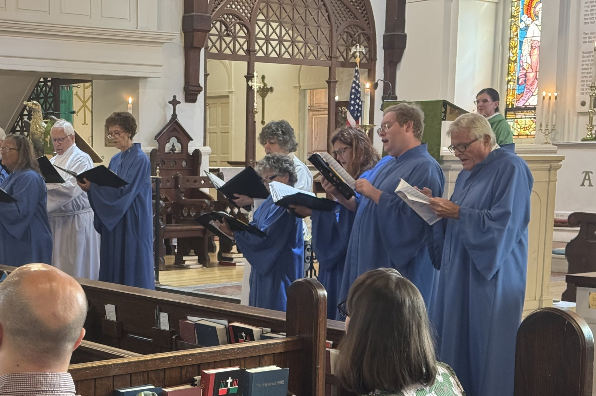 The choir, in blue robes, singing at the front of the church