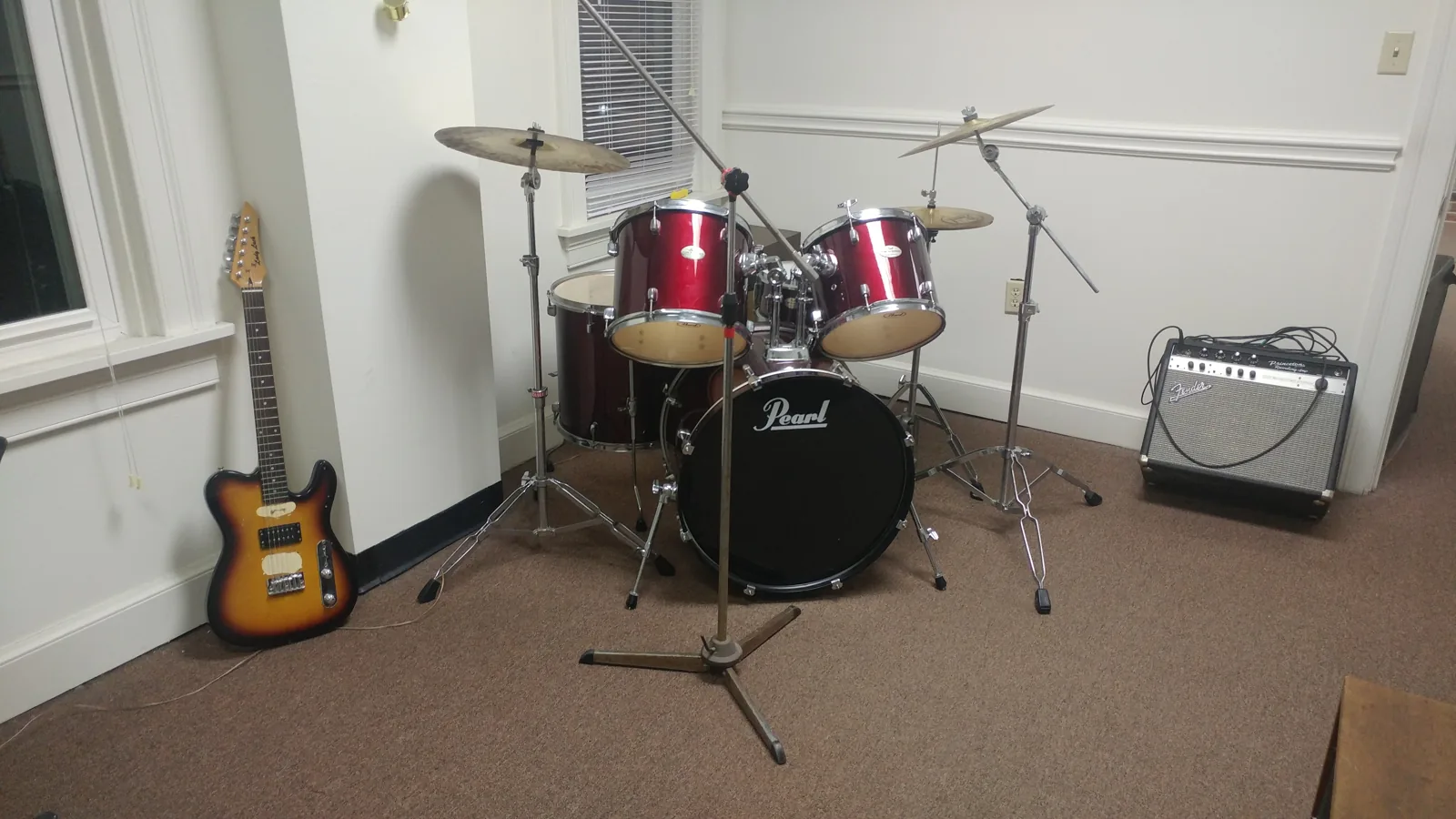 A drum kit, guitar and amplifier in the music room at the Hoffman House